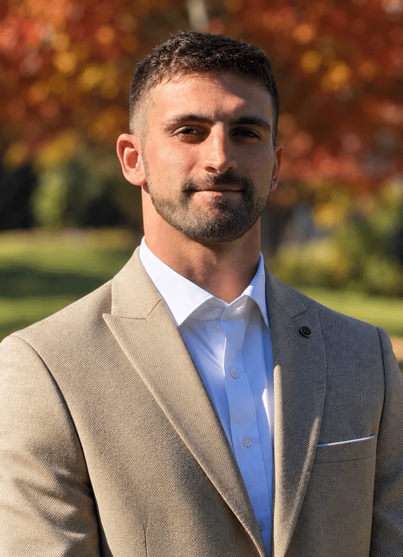 Cameron Vasquez wearing a suit in a professional outdoor portrait.