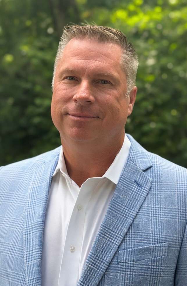 Mark Andreski wearing a suit in a professional outdoor portrait.